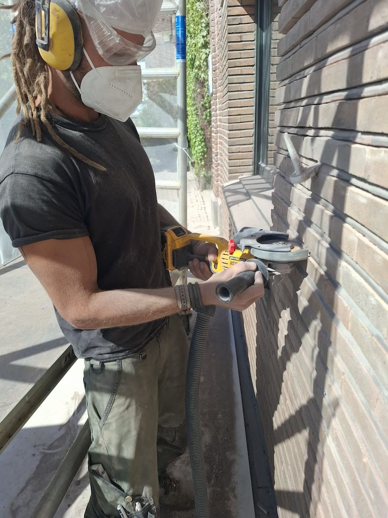 Geoffrey van De Bouwer bezig met gevelrenovatie